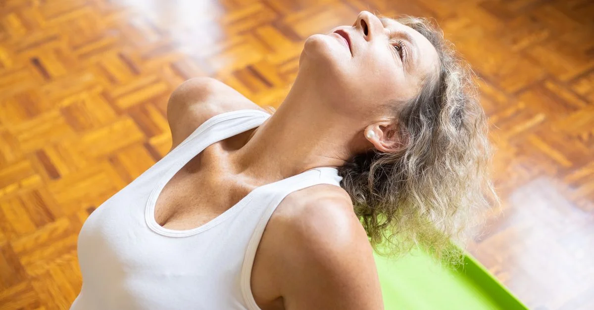 Une femme âgée s'étirant sur un tapis de yoga, promouvant la forme physique et un mode de vie sain.