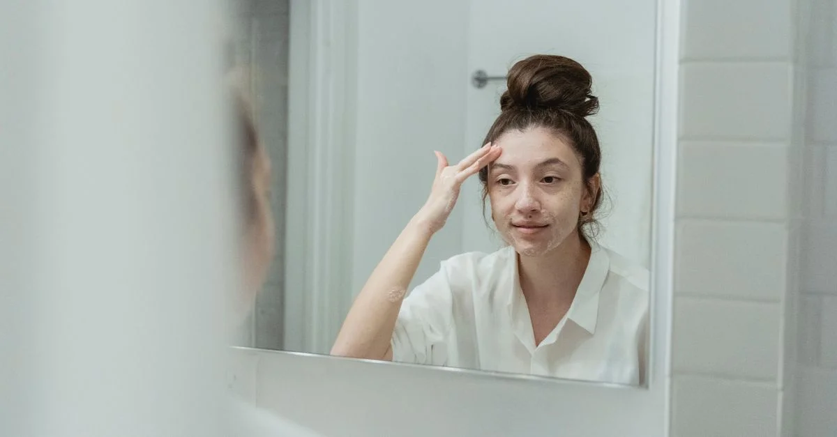 Femme dans la salle de bain appliquant de la crème faciale, reflétant le soin de soi et la détente.